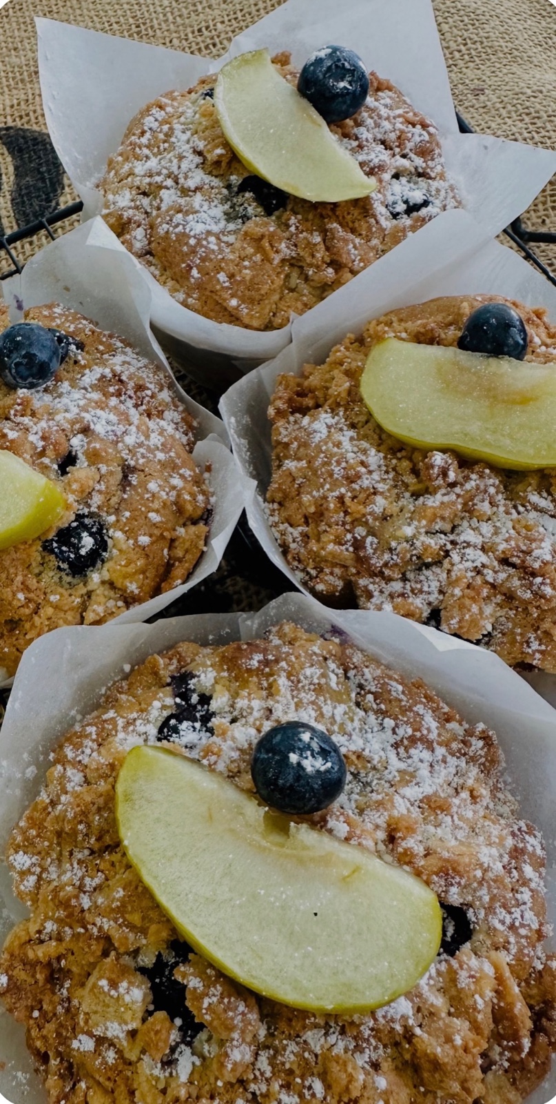 Fresh muffins topped with blueberries and apple slices